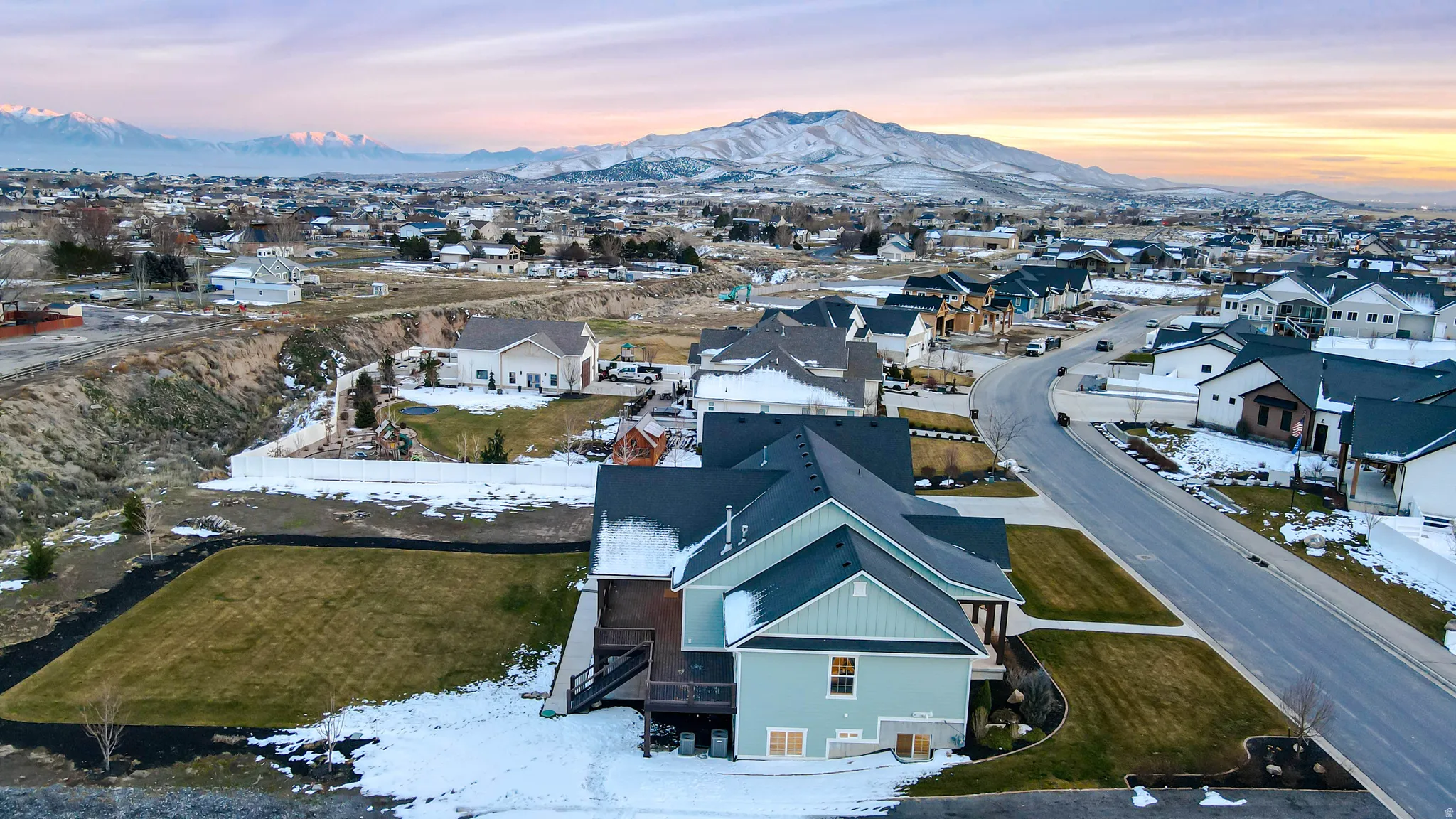 Snowy aerial view featuring a mountain view and a residential view