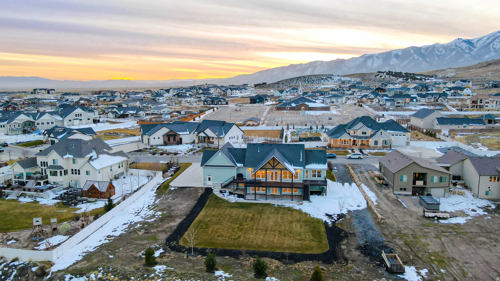 Snowy aerial view featuring a mountain view and a residential view