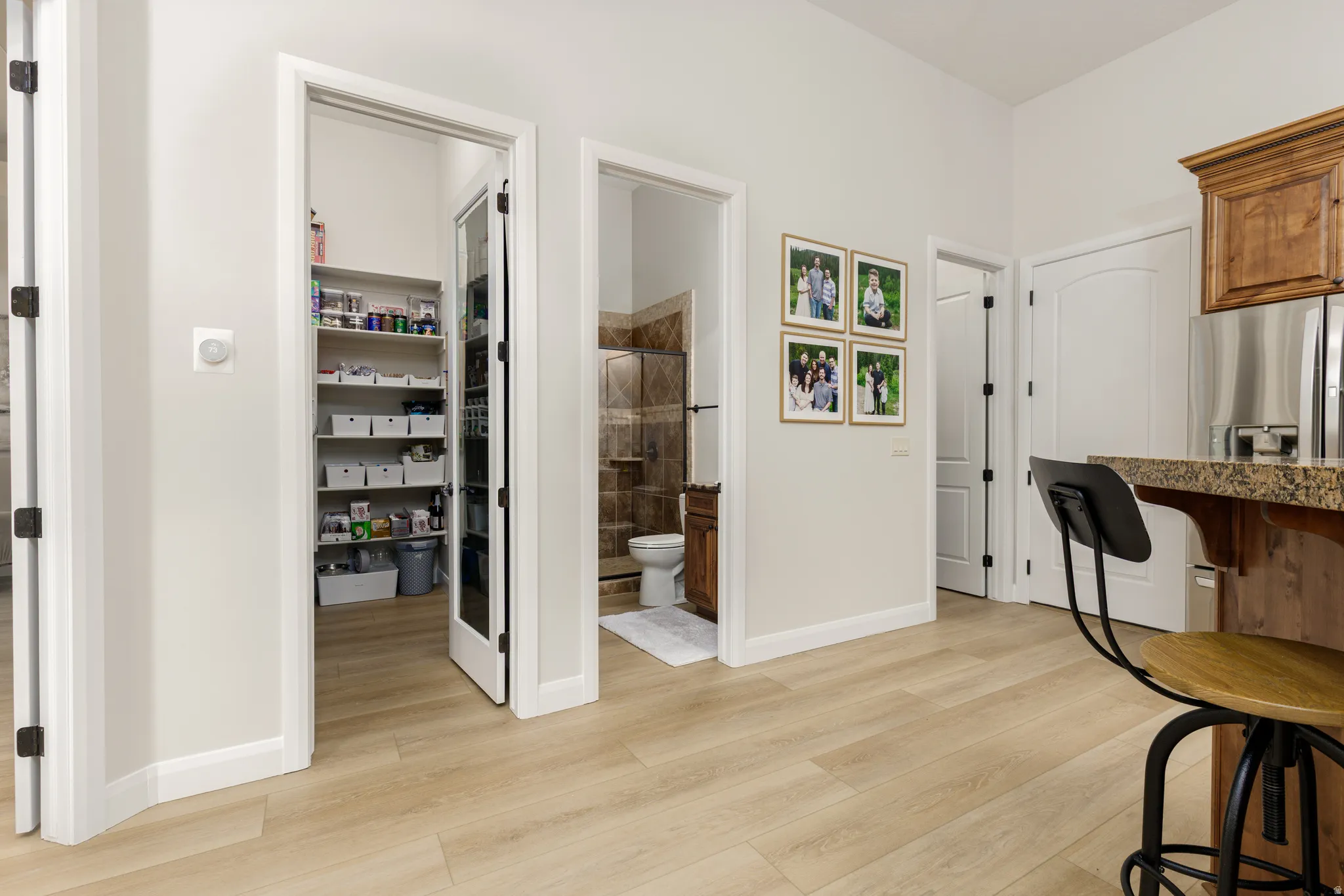 Kitchen featuring a kitchen breakfast bar, light wood finished floors, stainless steel fridge with ice dispenser, and wood finish cabinetry