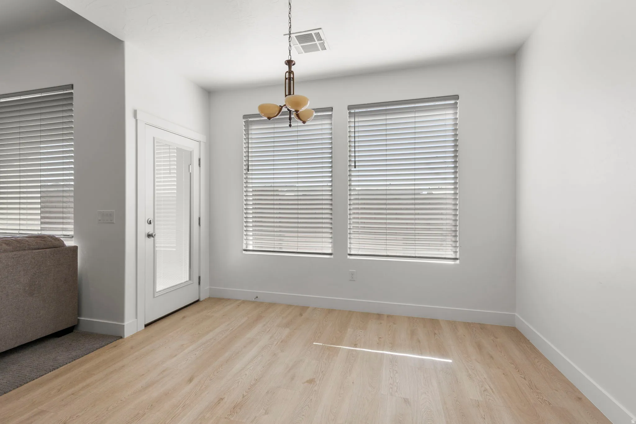 Unfurnished dining area with light wood finished floors and baseboards