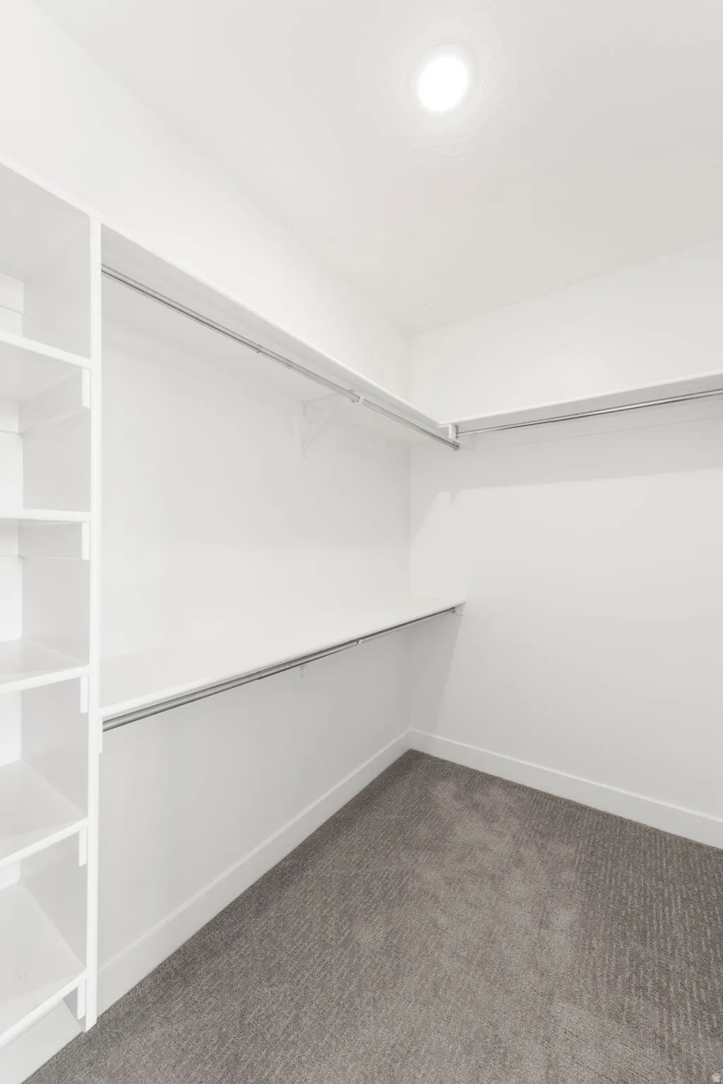 Spacious closet with dark carpet