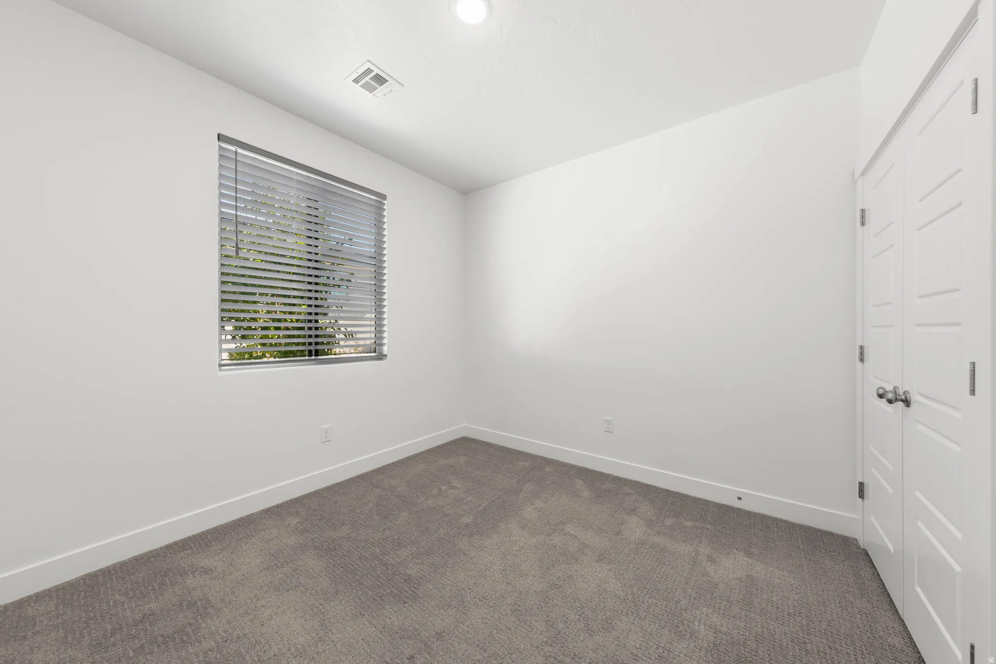 Unfurnished bedroom featuring a closet and dark colored carpet
