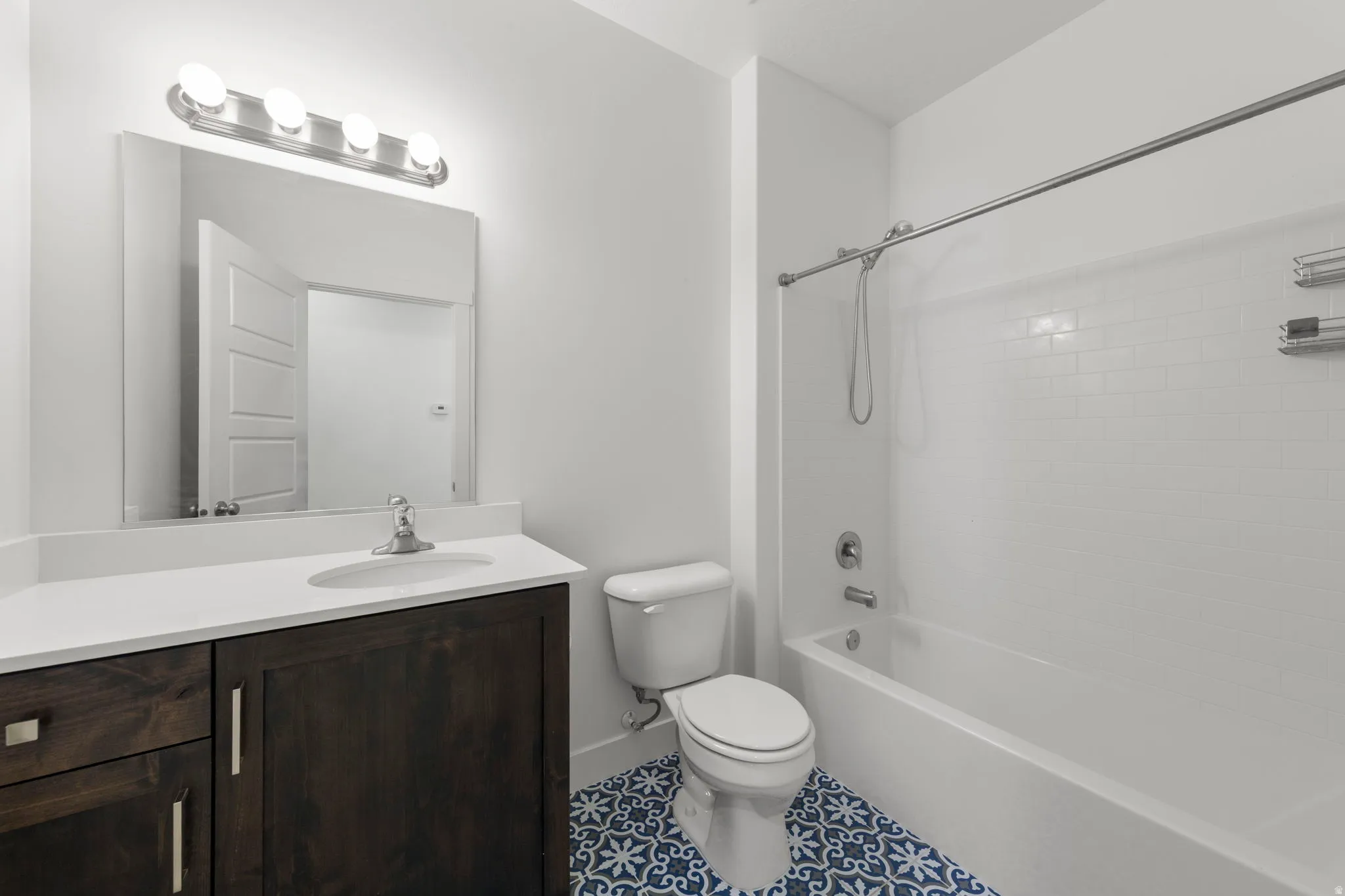 Bathroom with bathtub / shower combination, vanity, and tile patterned floors