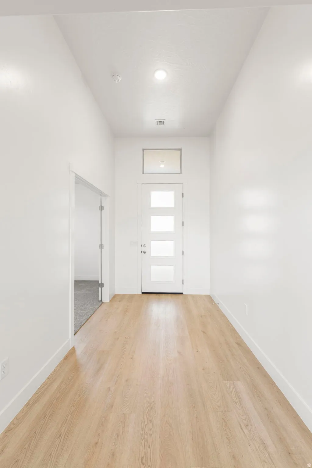 Foyer featuring light wood finished floors and baseboards