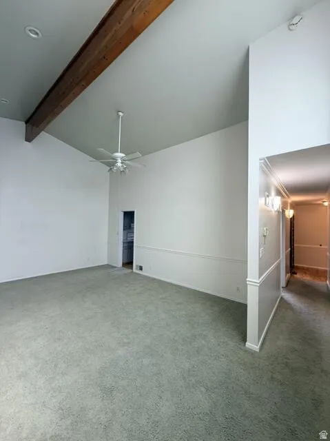 Unfurnished living room featuring carpet flooring and a ceiling fan