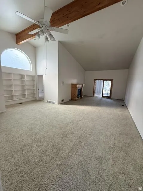 Bonus room with carpet, beamed ceiling, a ceiling fan, and high vaulted ceiling