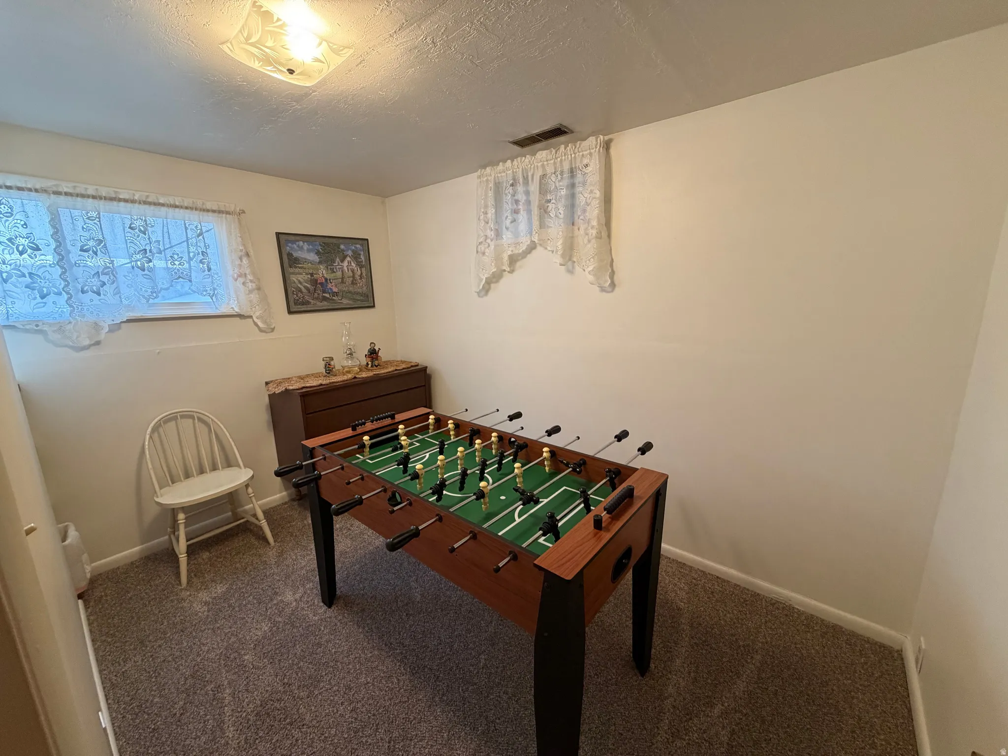 Game room featuring carpet and a textured ceiling