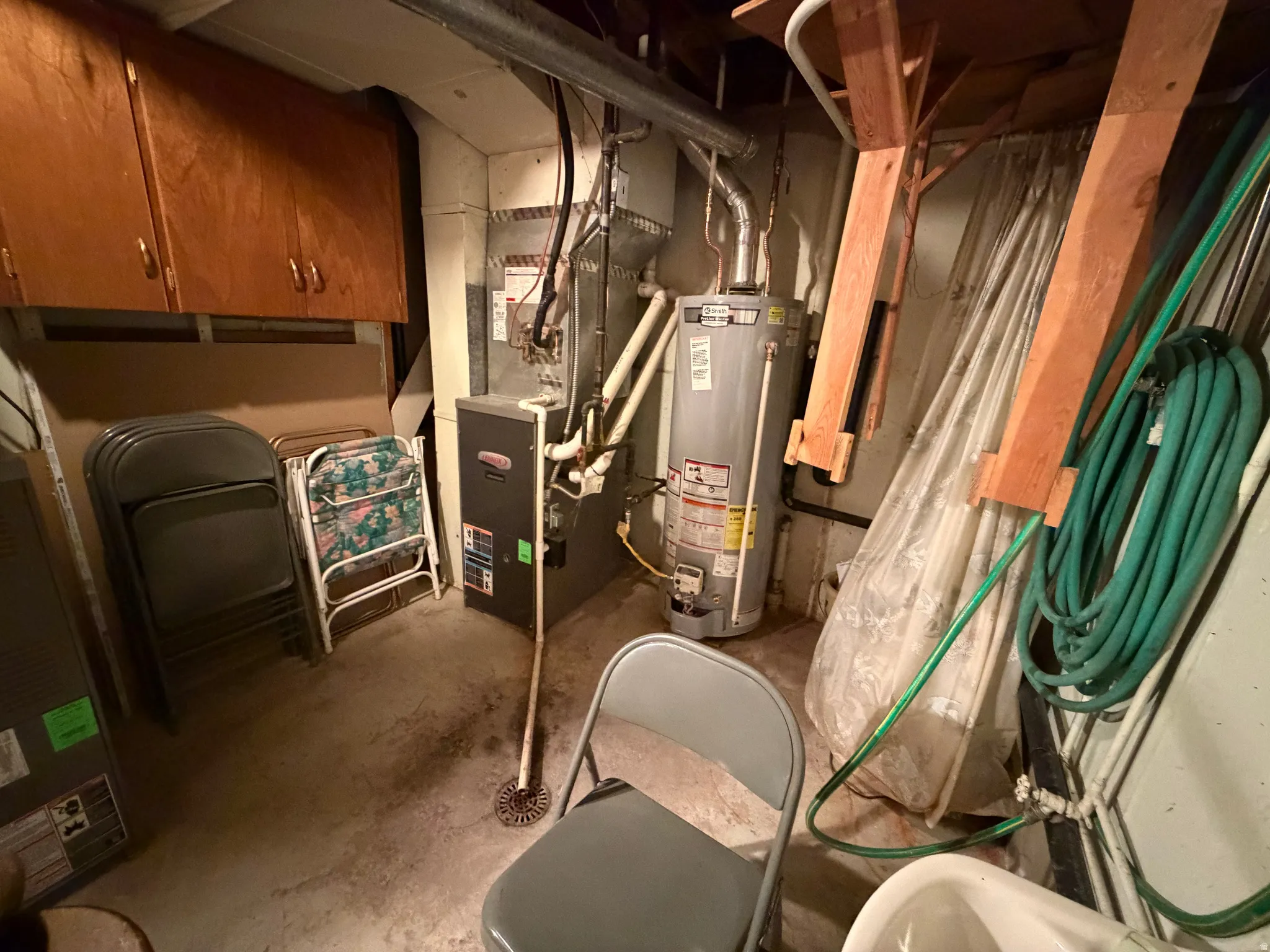 Utility room featuring gas water heater and heating unit