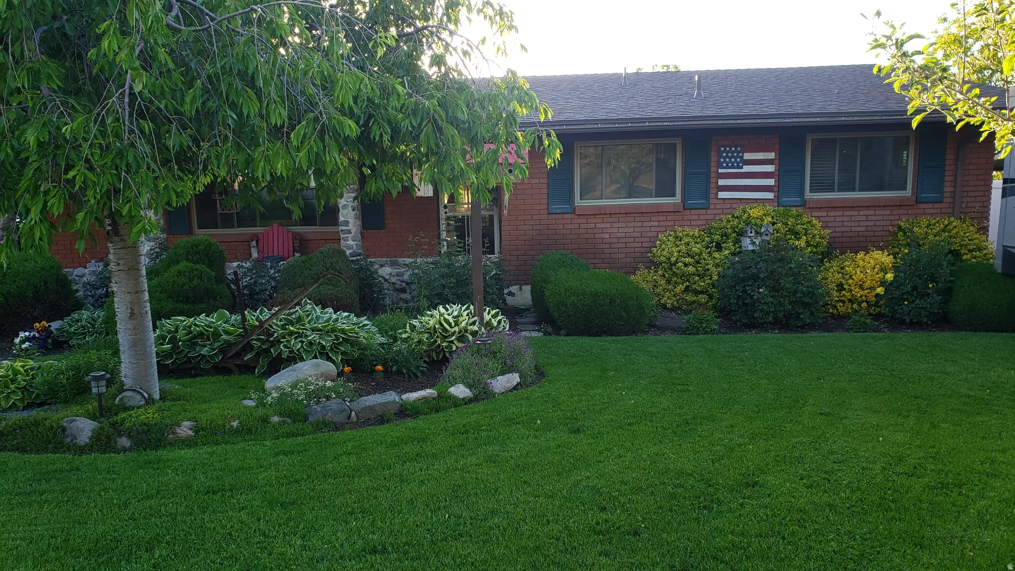 View of front facade featuring brick siding, a shingled roof, and a front lawn