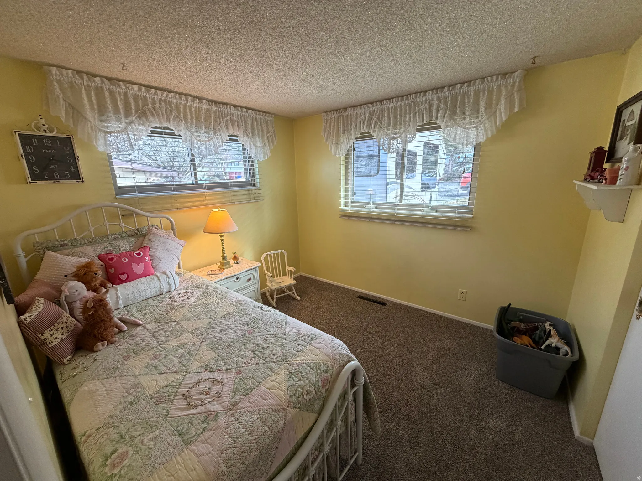 Bedroom featuring dark carpet and a textured ceiling