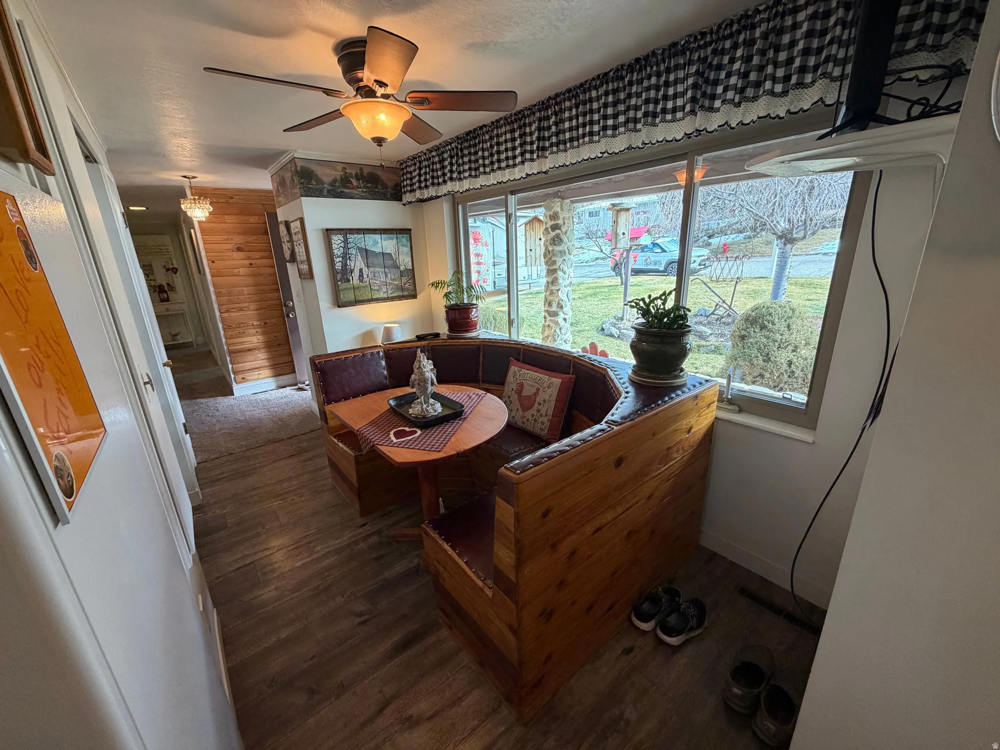 Living room featuring wood finished floors, a ceiling fan, and wood walls