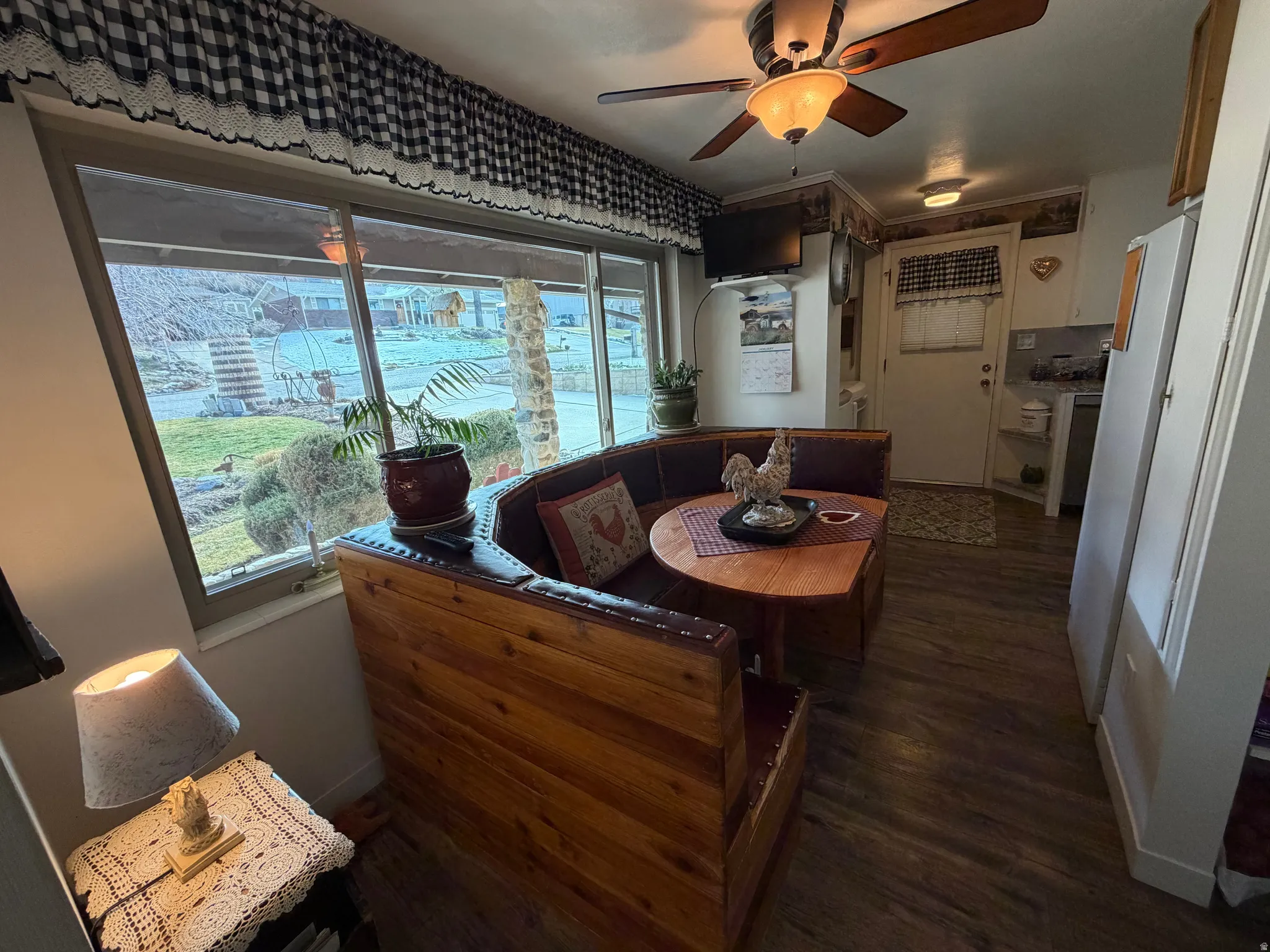 Dining space with a ceiling fan and dark wood-style floors