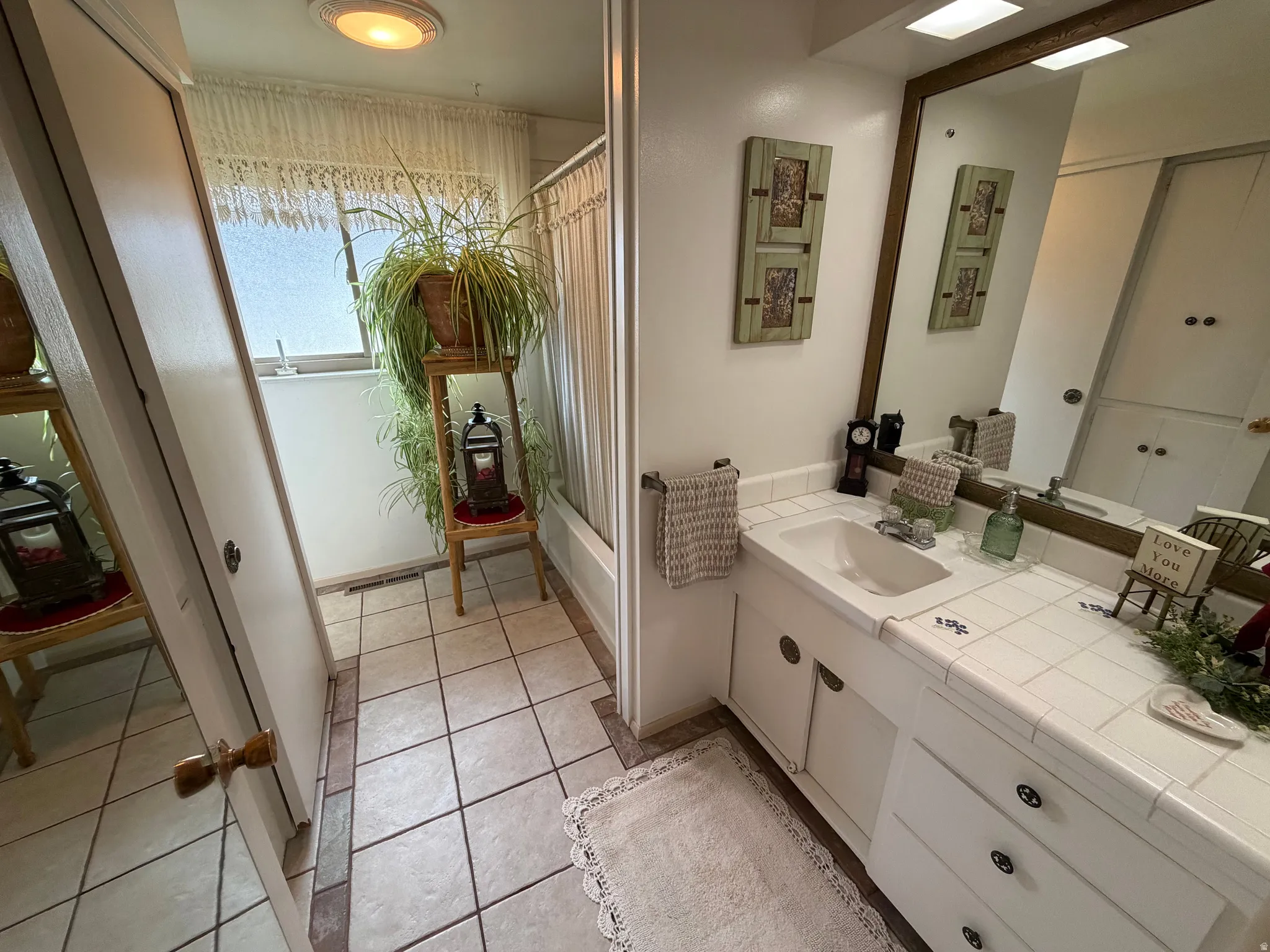 Full bathroom featuring shower / tub combo, vanity, and light tile patterned floors