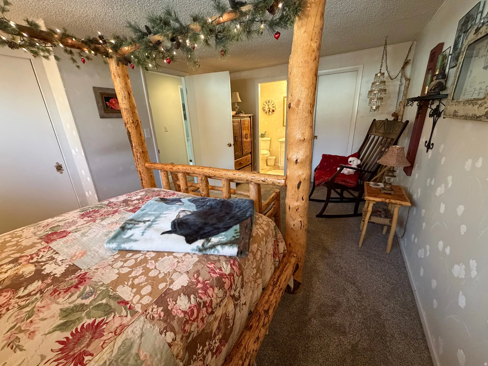 Bedroom featuring carpet floors, a textured ceiling, and ensuite bath