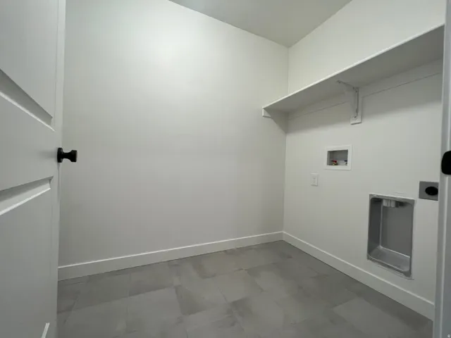 Washroom with baseboards and hookup for a washing machine