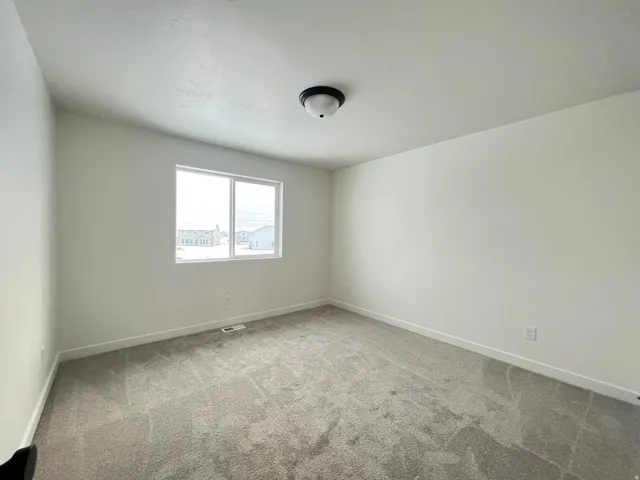 Carpeted spare room with baseboards