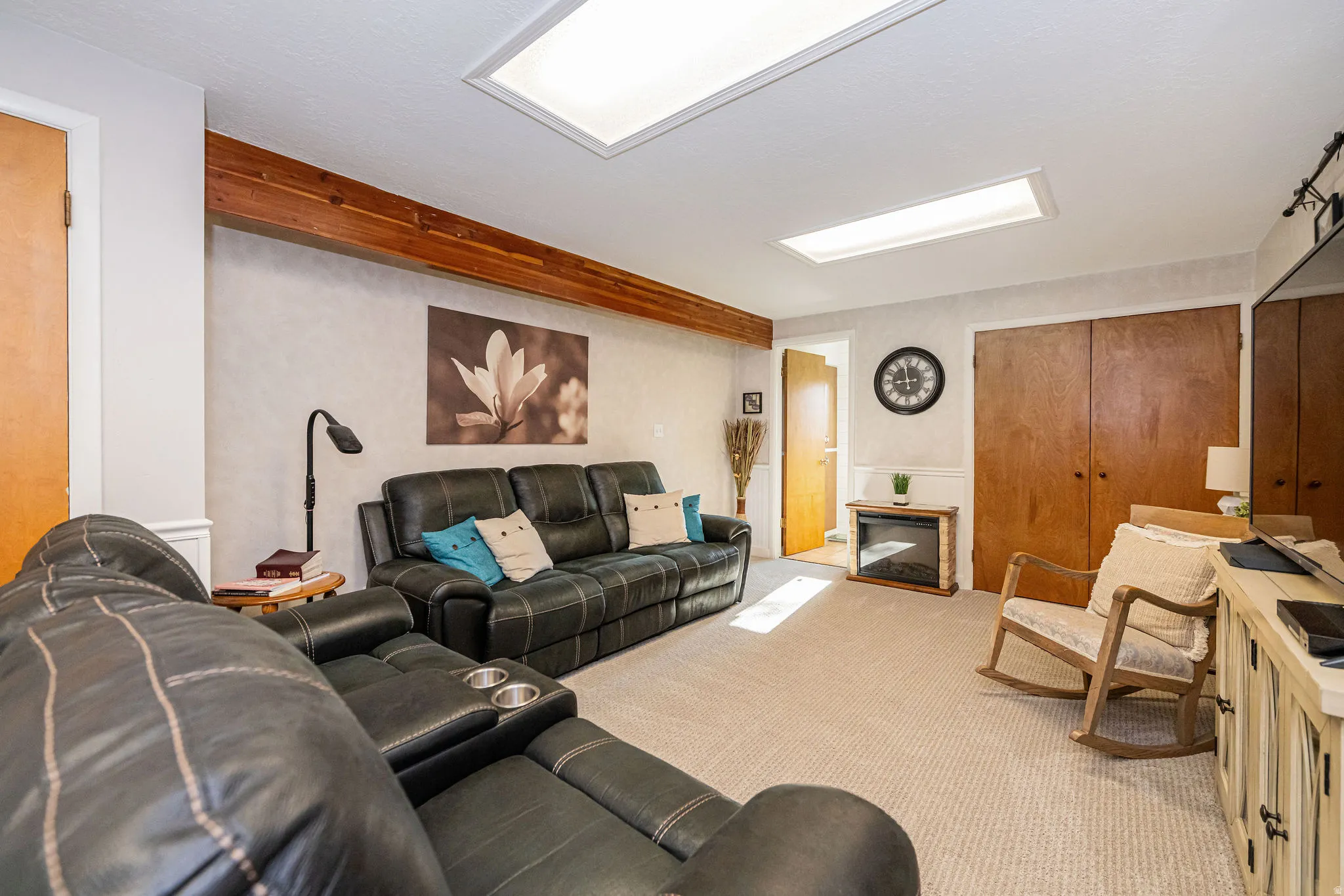 Carpeted living area with a glass covered fireplace