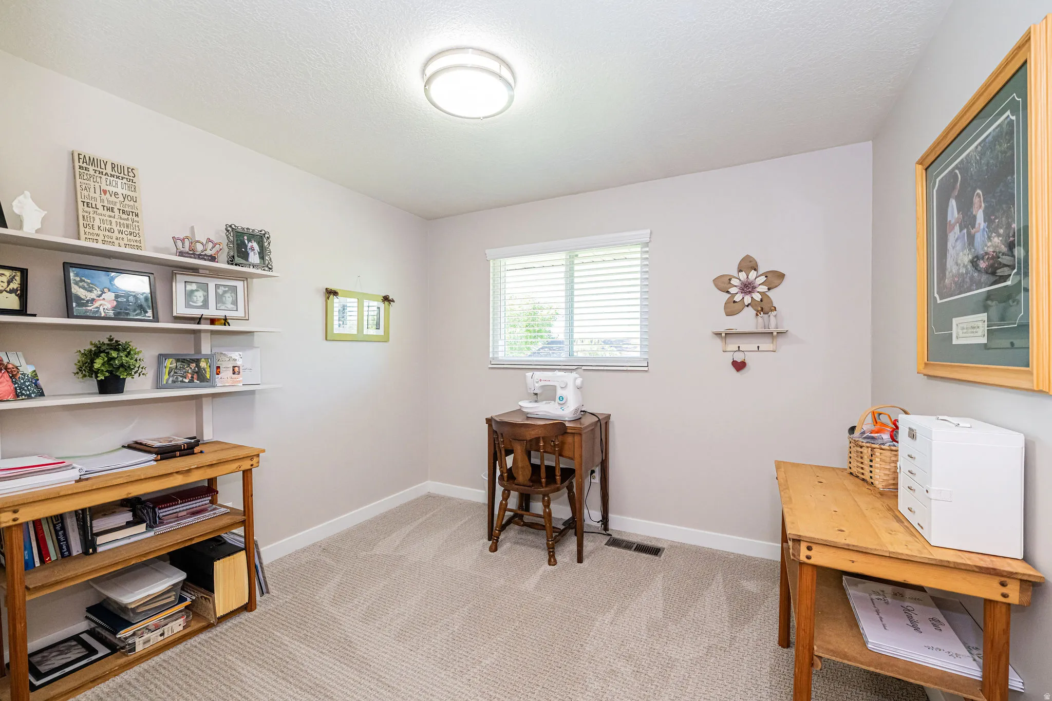 Home office with light colored carpet and a textured ceiling
