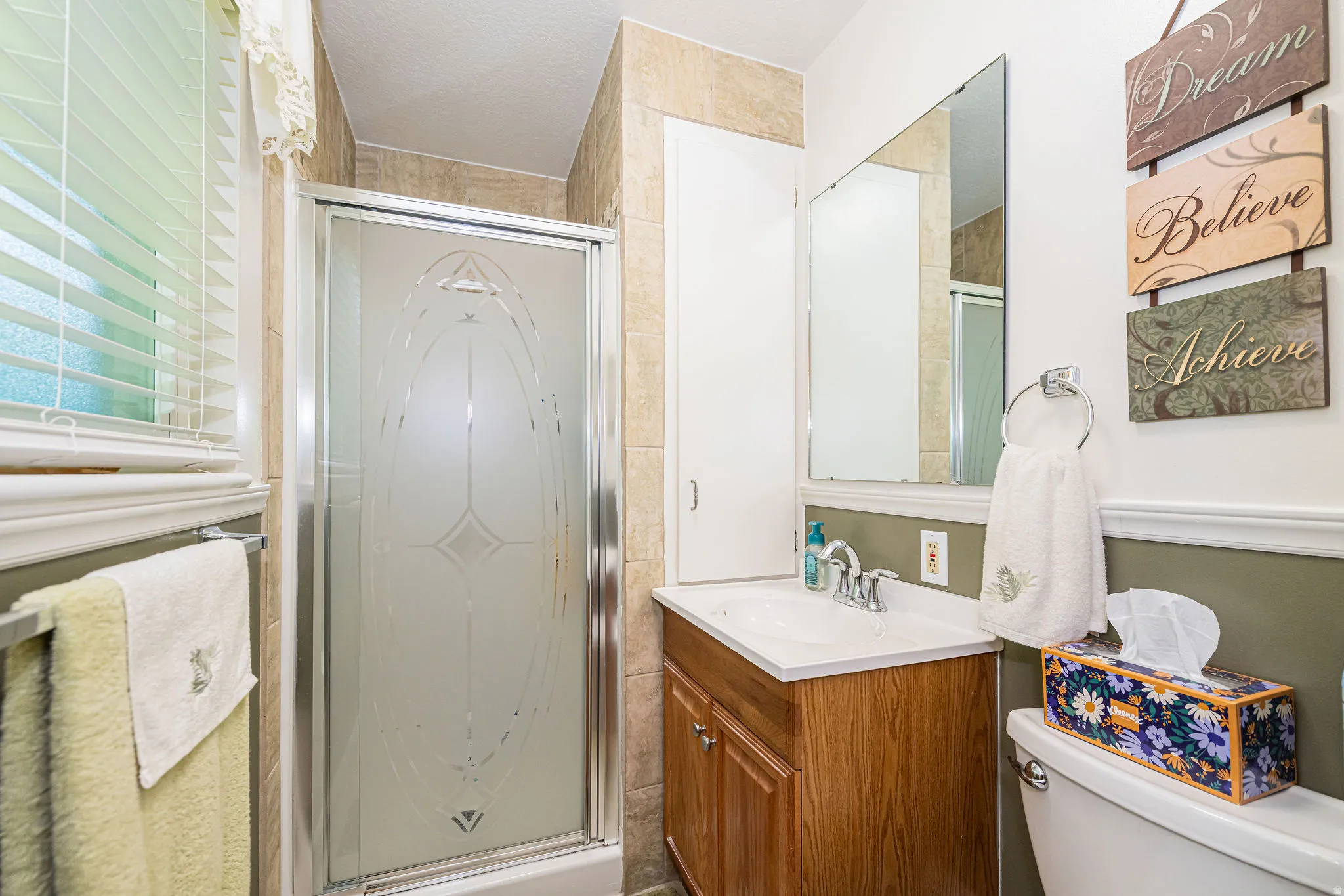 Full bathroom with a shower stall, vanity, and a textured ceiling