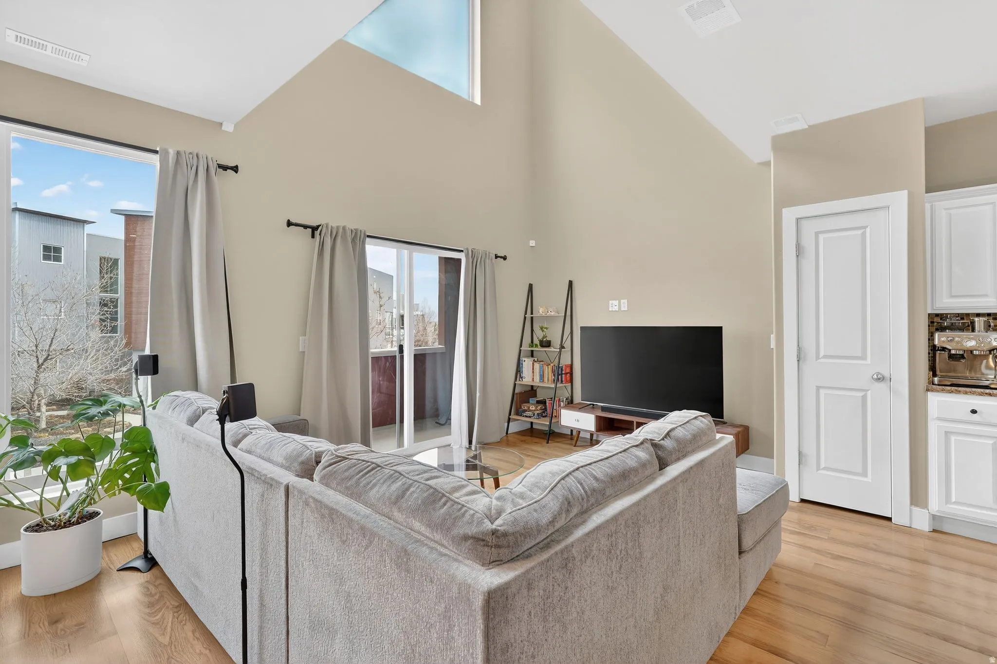 Living area featuring light wood-style floors and high vaulted ceiling