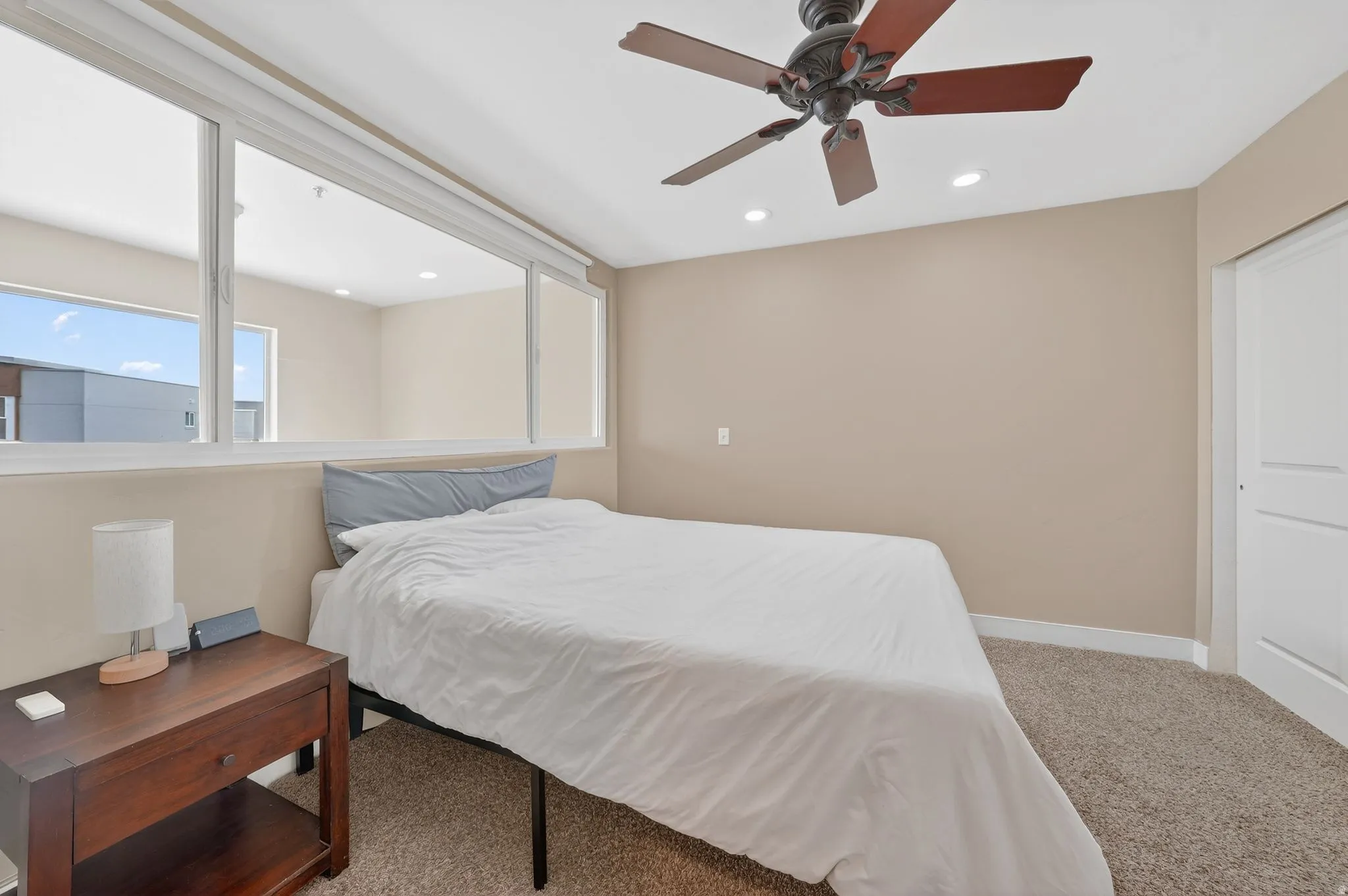 Bedroom with light colored carpet, a ceiling fan, and recessed lighting