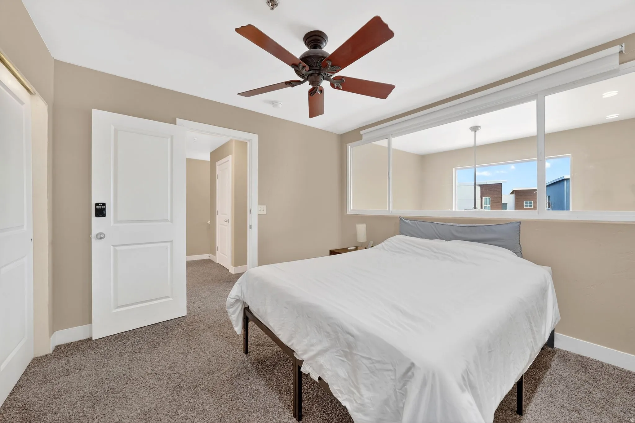Carpeted bedroom with baseboards and a ceiling fan