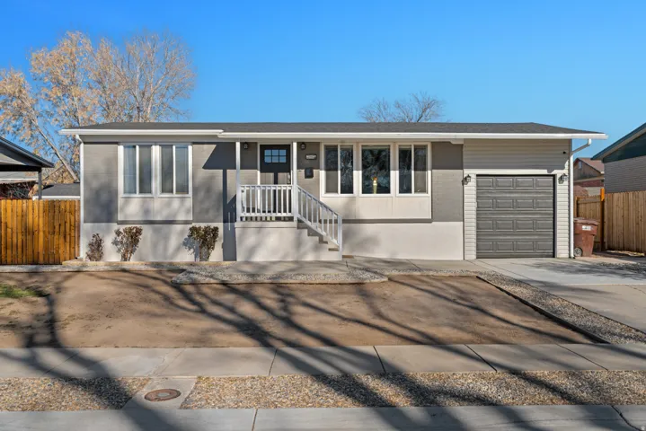 View of front of property featuring concrete driveway, a garage, covered porch, and brick siding