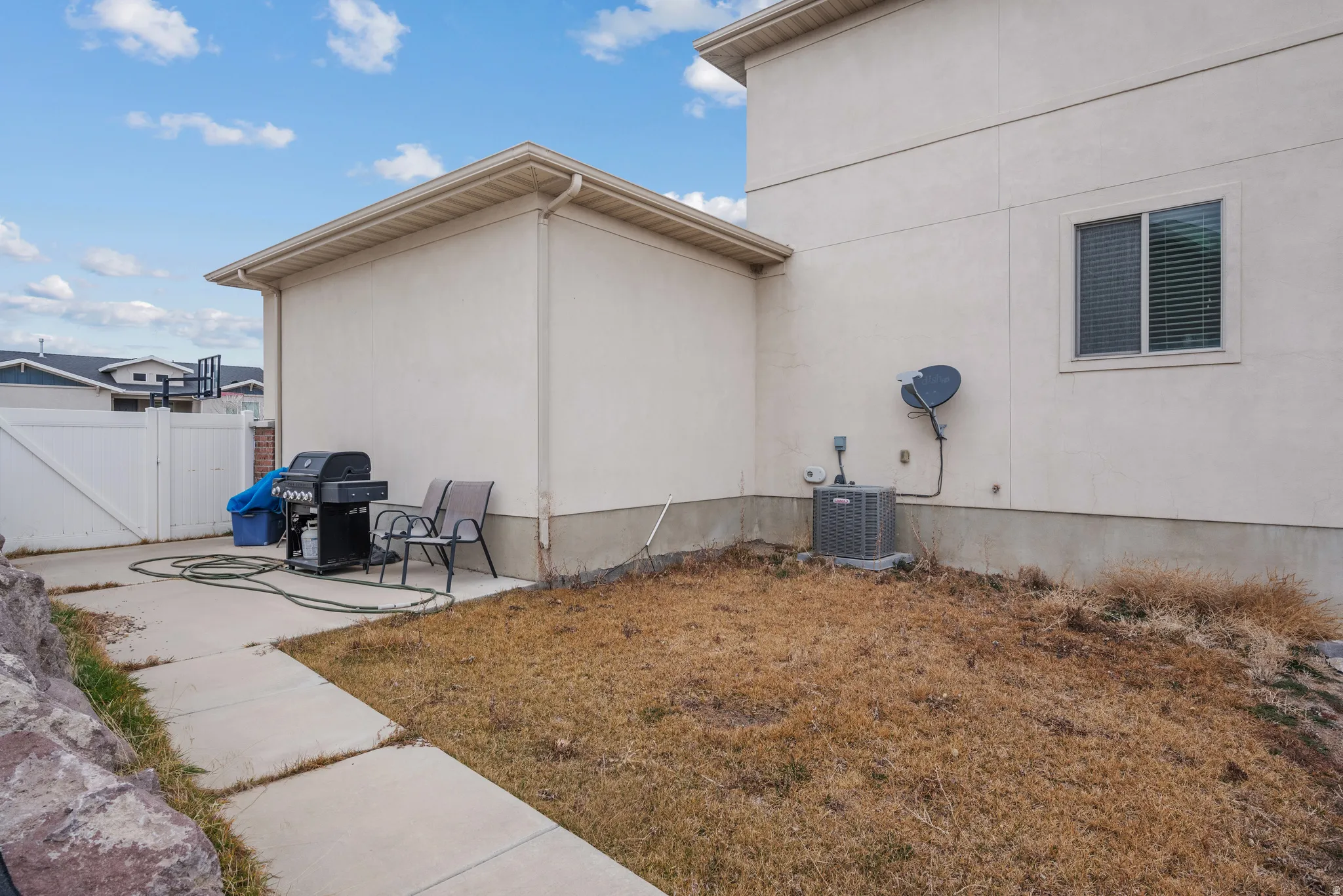 View of side of property with a patio area, a gate, and stucco siding