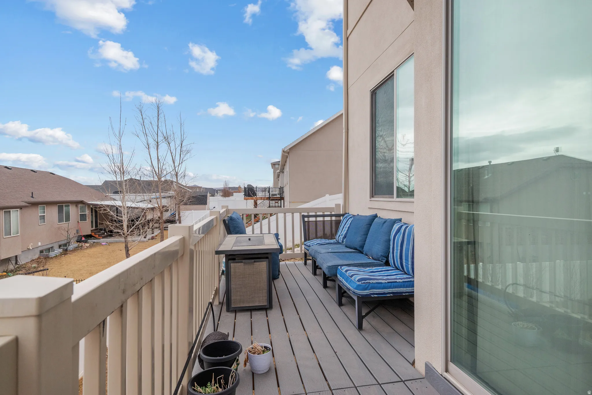 Wooden deck with area for grilling, a residential view, and an outdoor hangout area
