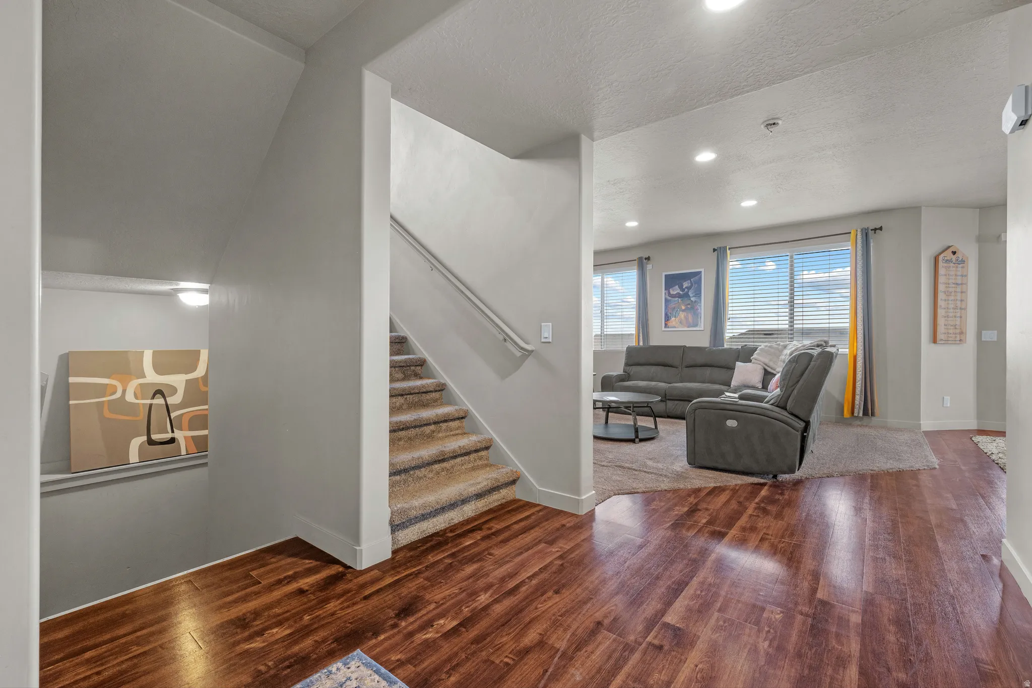 Living area featuring dark wood-type flooring, recessed lighting, and a textured ceiling
