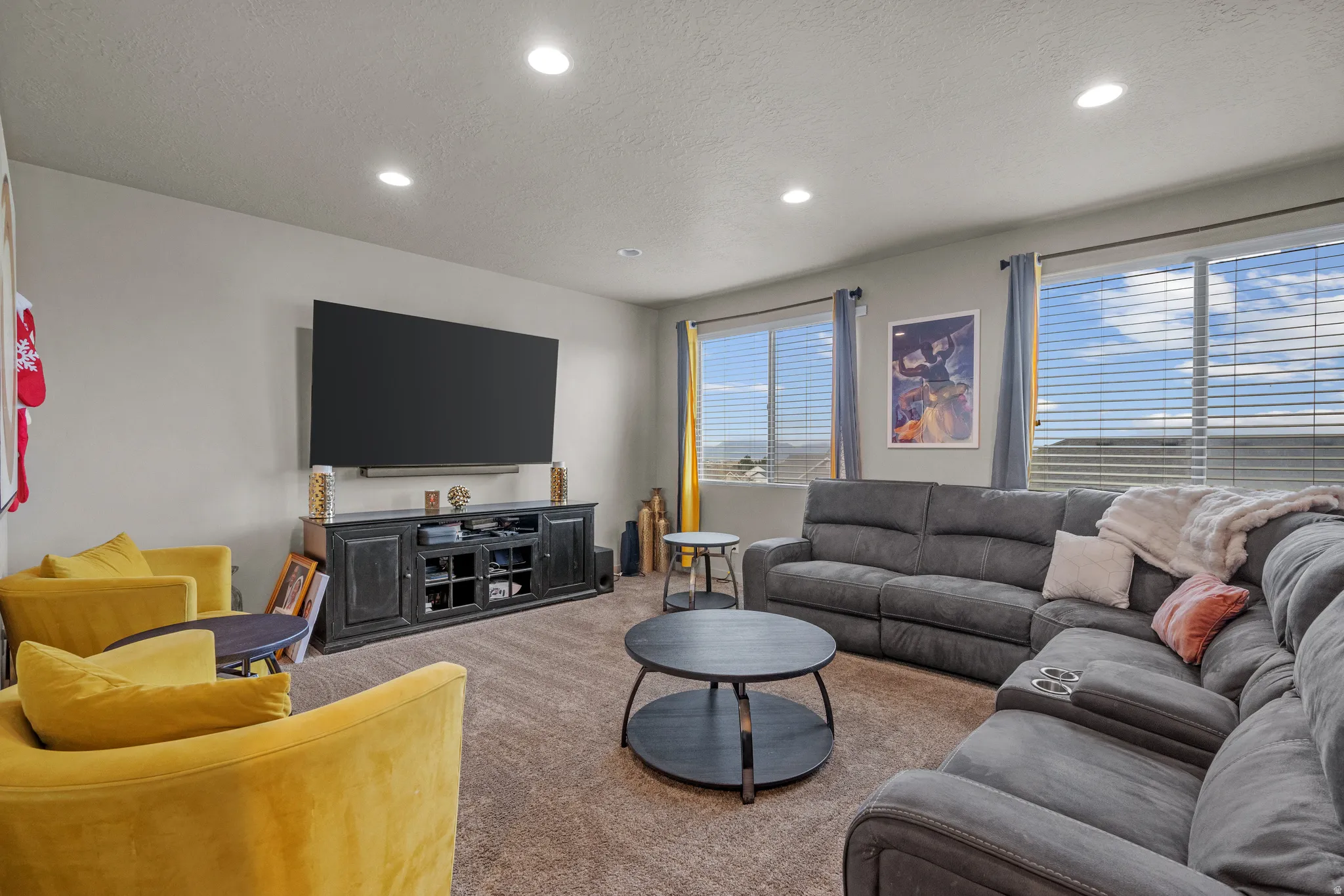 Living area featuring recessed lighting, light colored carpet, and a textured ceiling