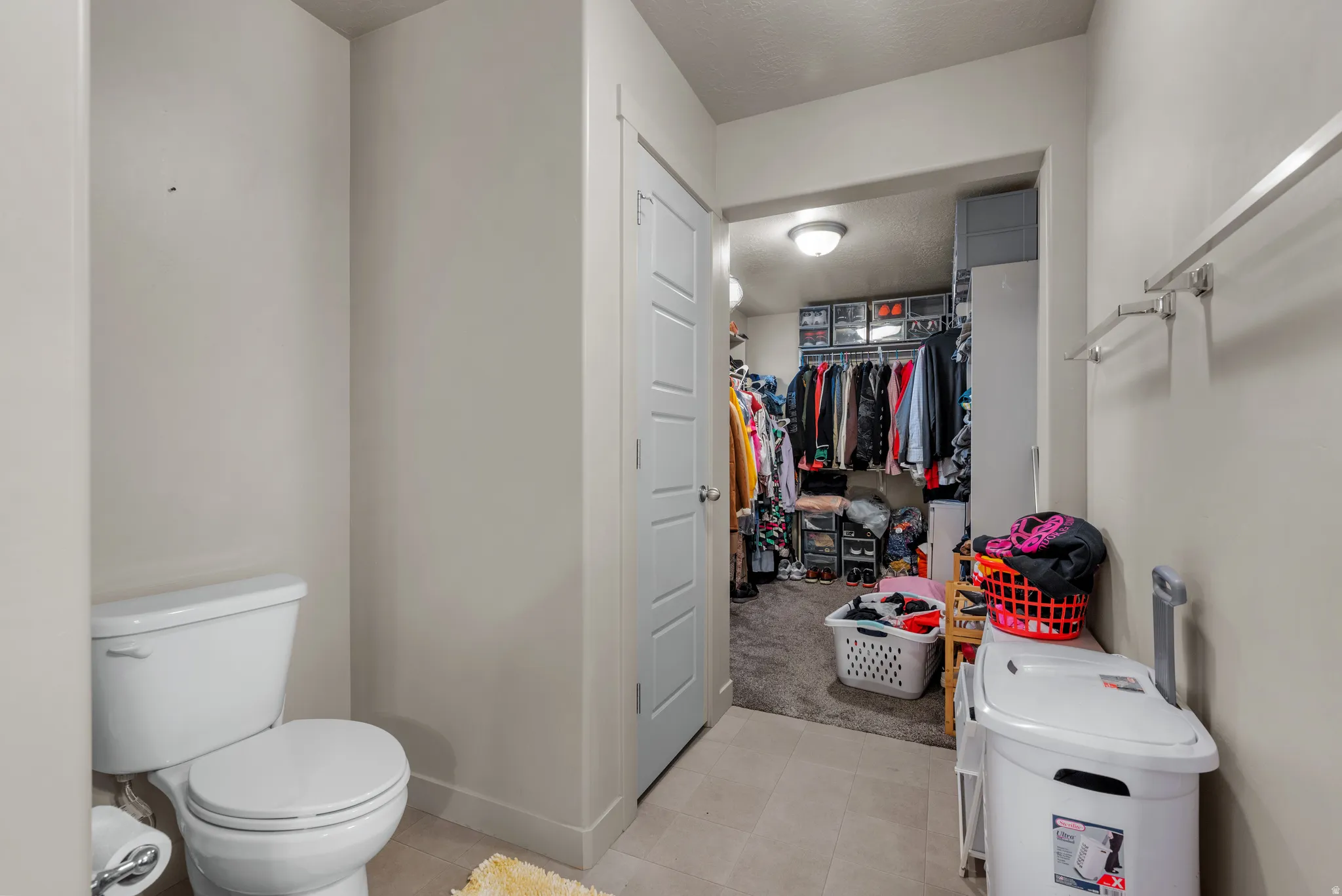 Bathroom featuring a walk in closet and light tile patterned flooring