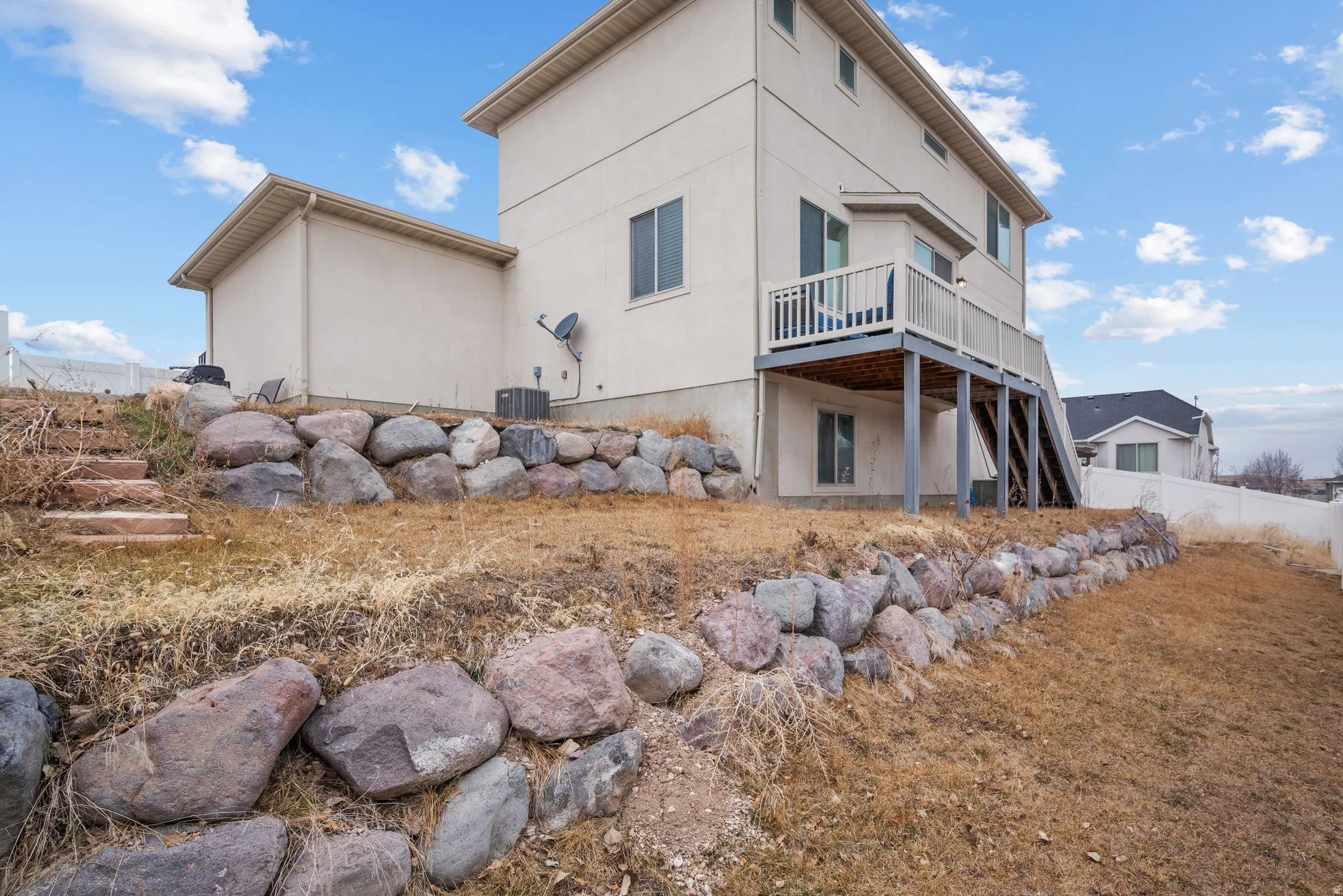 Back of house with a wooden deck and stucco siding