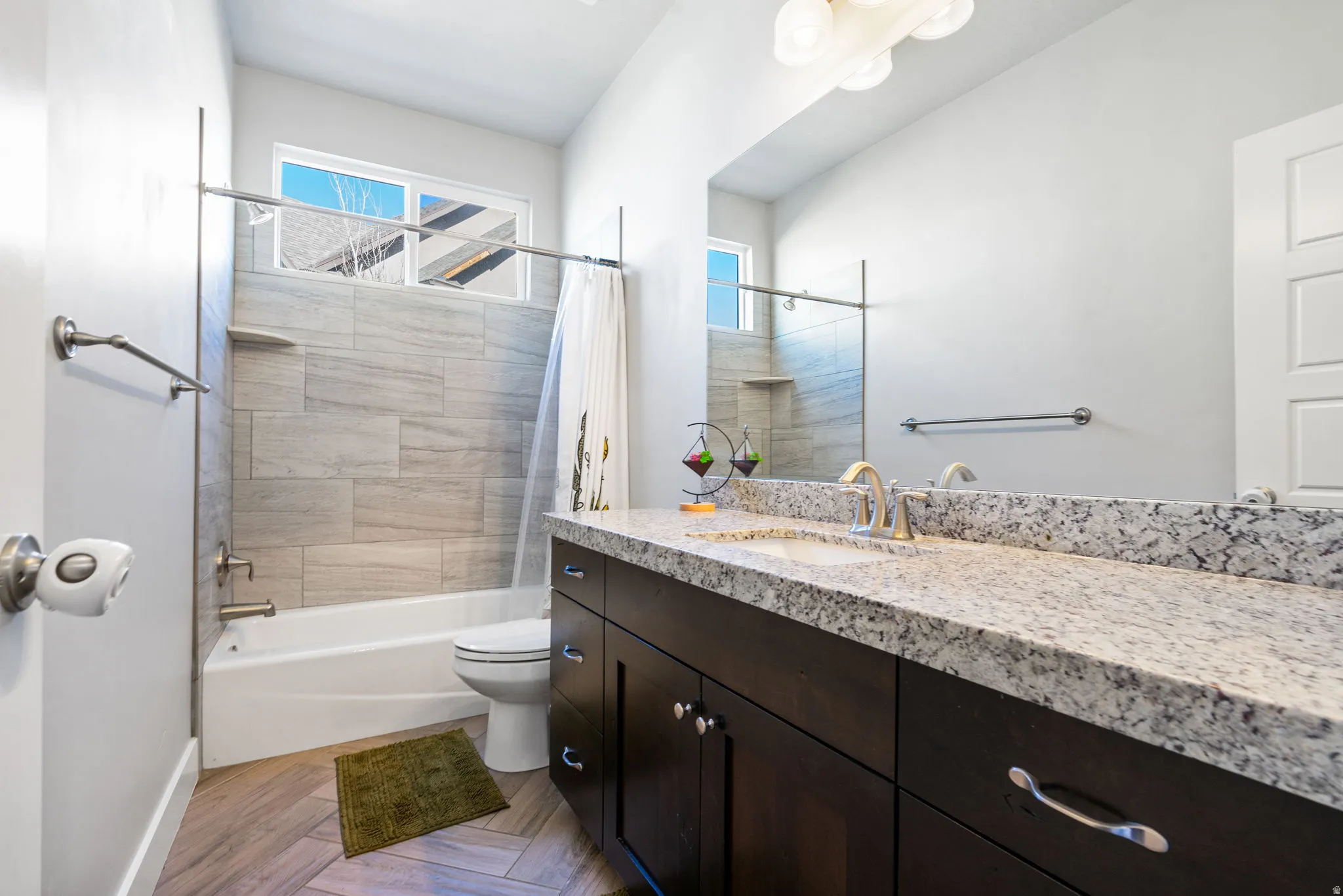 Bathroom with shower / tub combo, vanity, and parquet floors