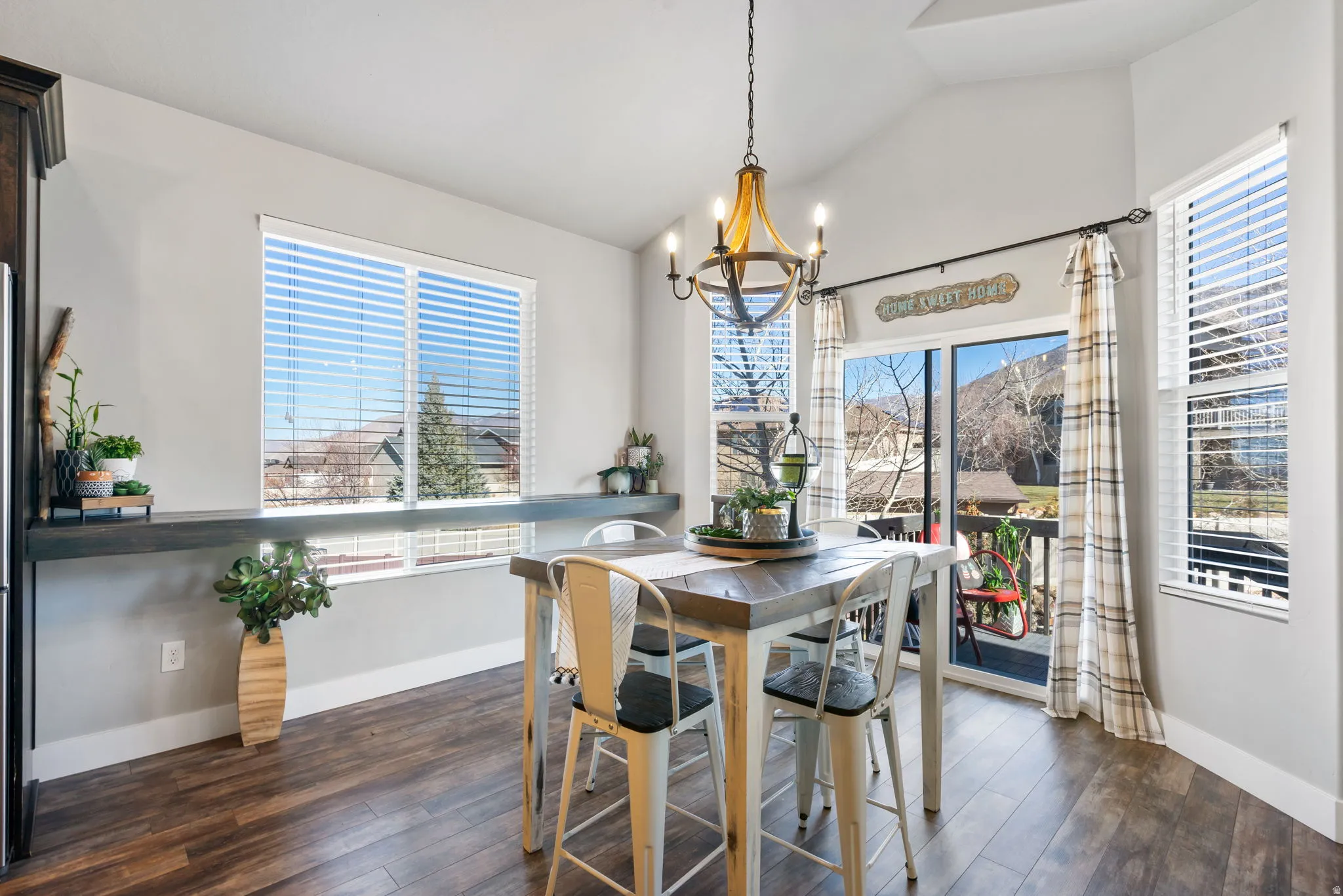 Dining room featuring dark wood-type flooring, a chandelier, and vaulted ceiling