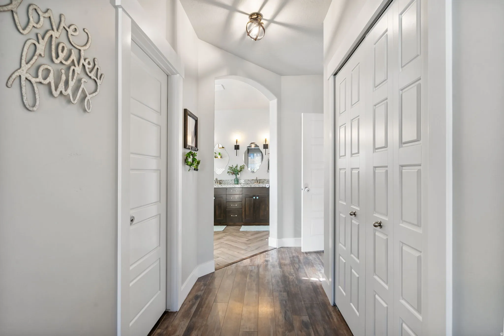 Hallway featuring dark wood-style flooring and arched walkways