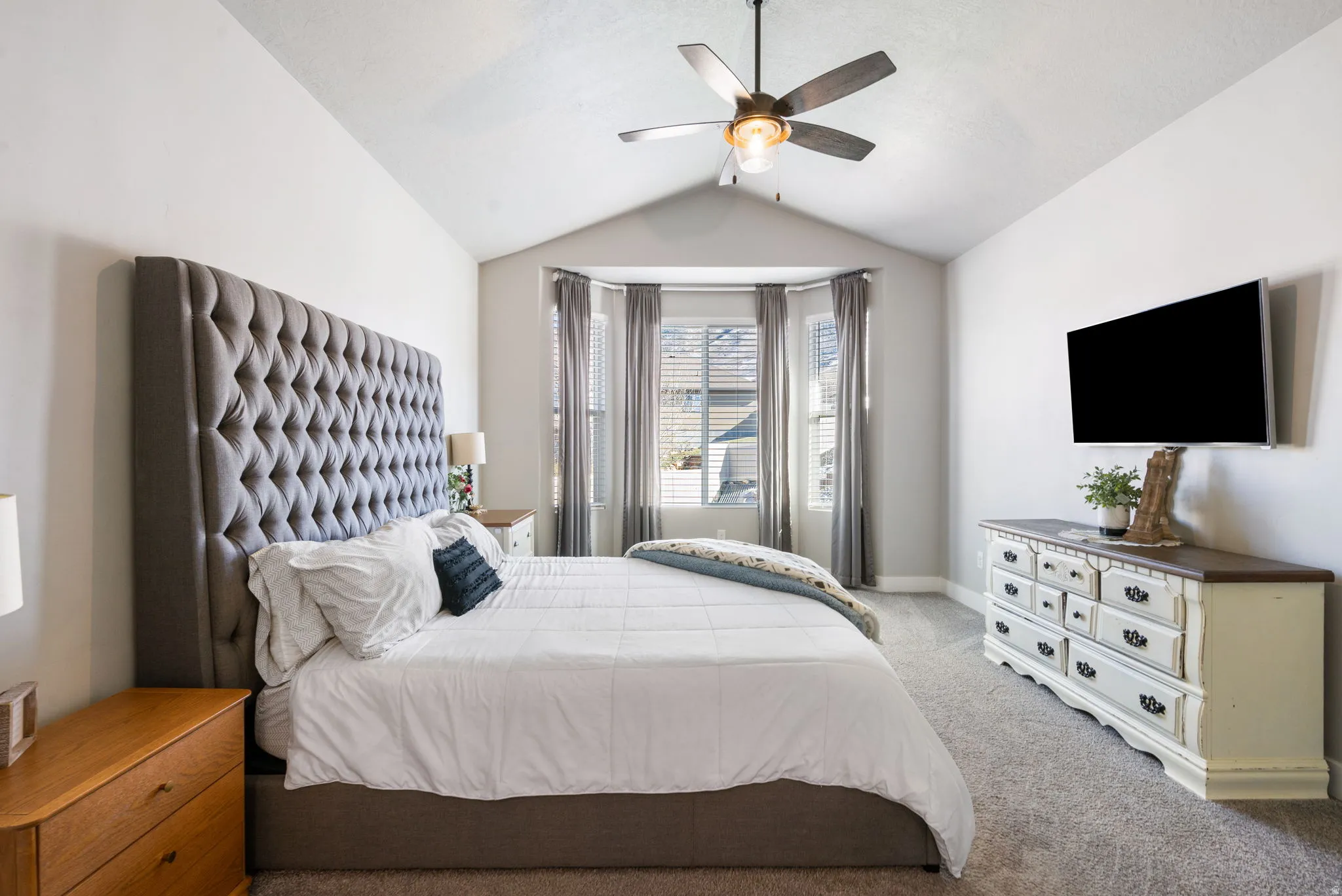 Bedroom with lofted ceiling, carpet flooring, and ceiling fan