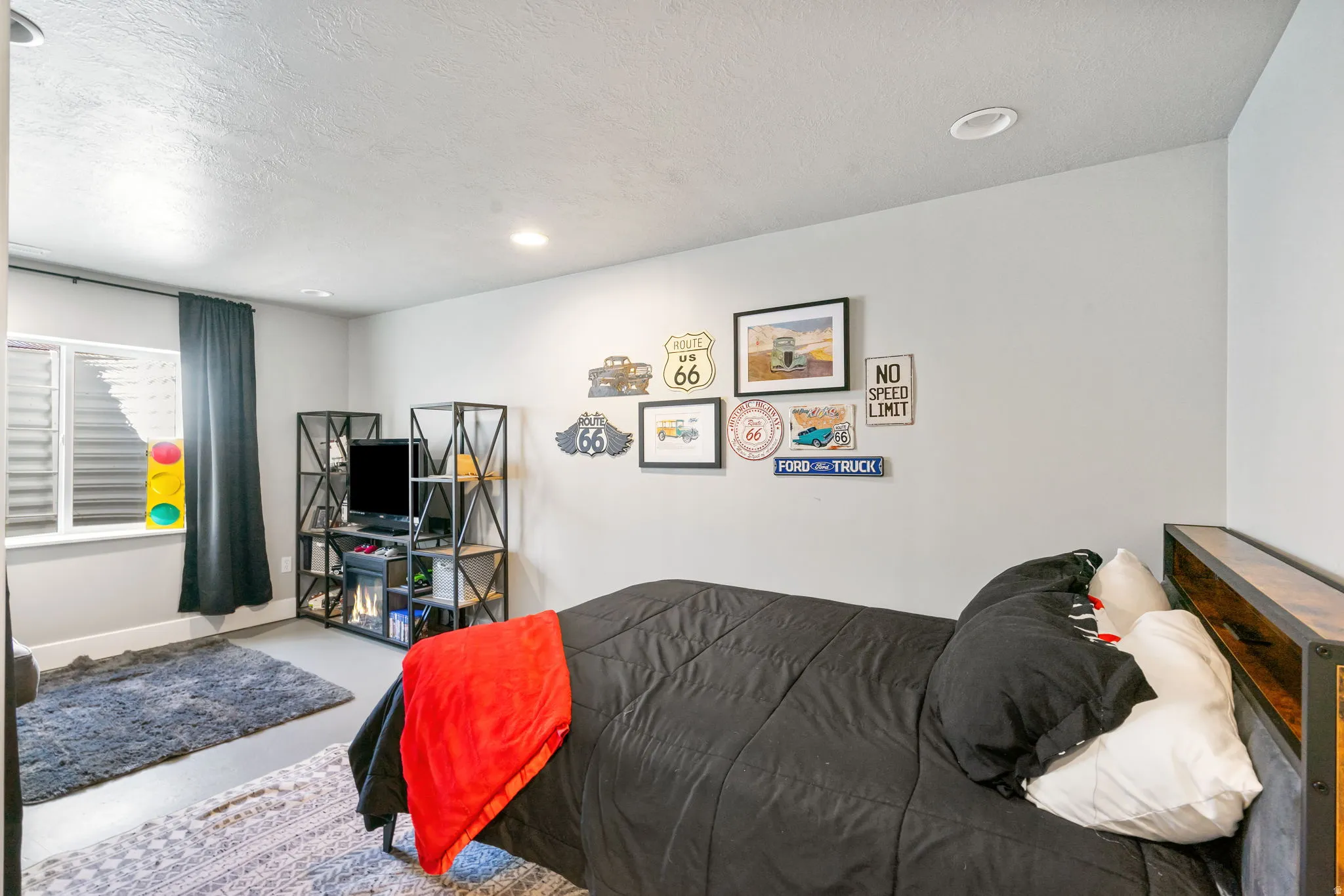 Bedroom with a textured ceiling, finished concrete flooring, and recessed lighting