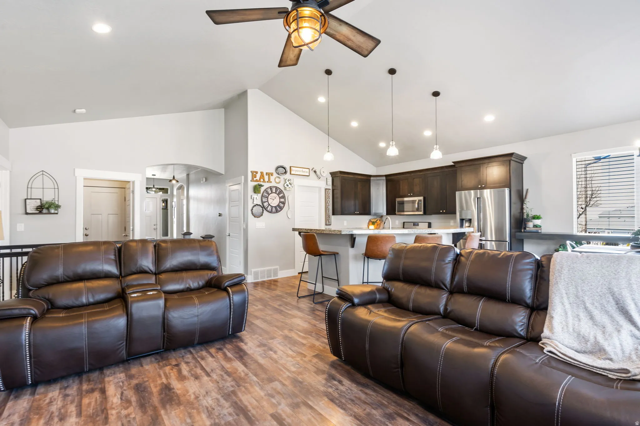 Living room with high vaulted ceiling, dark wood-style flooring, a ceiling fan, and recessed lighting