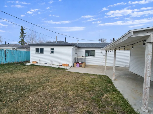 Rear view of house featuring a patio and a shingled roof