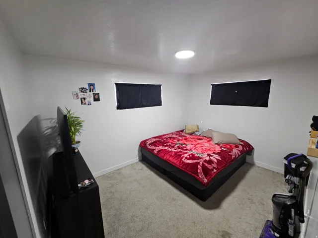 Bedroom featuring light colored carpet and baseboards