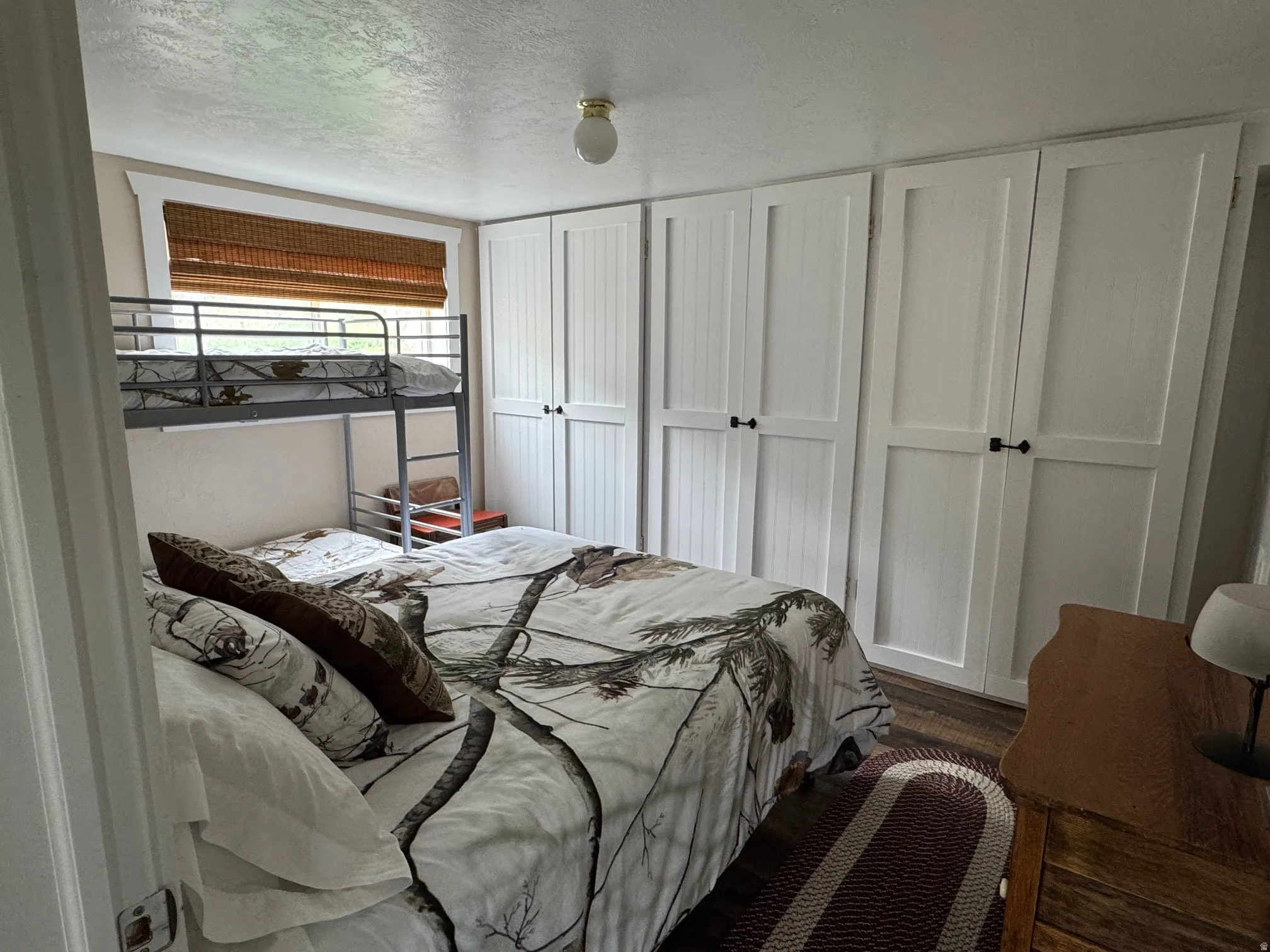 Bedroom featuring a textured ceiling and wood finished floors
