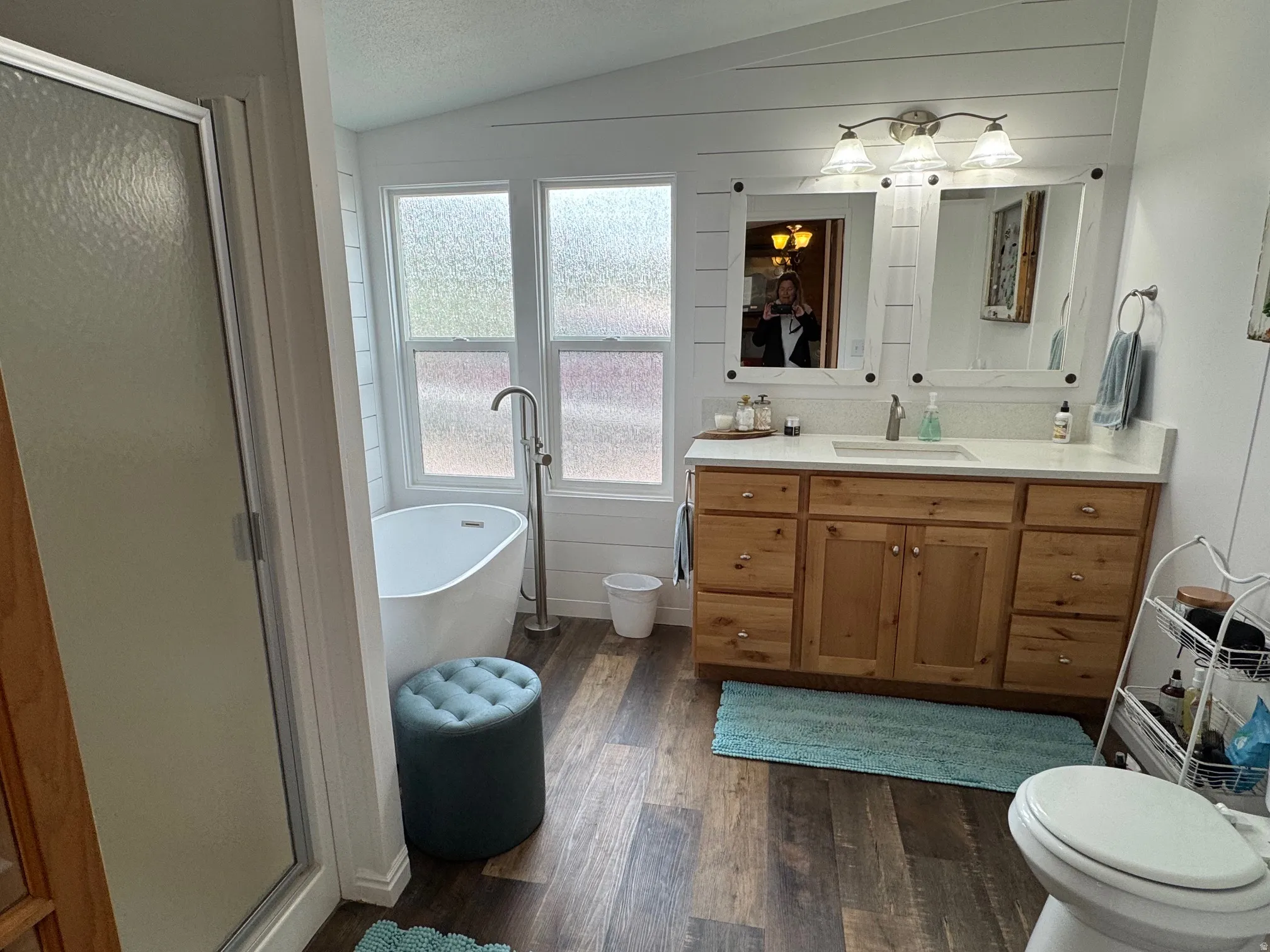 Full bath featuring vanity, a shower stall,  LVT floors, a freestanding bath