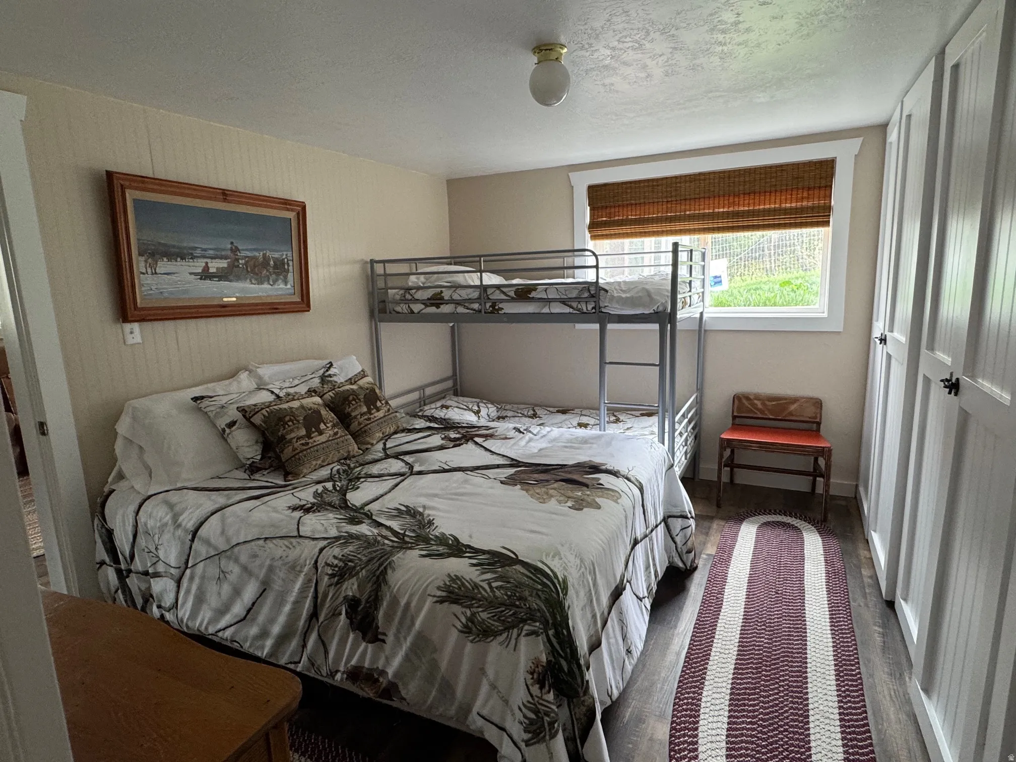 Bedroom with a textured ceiling and wood finished floors