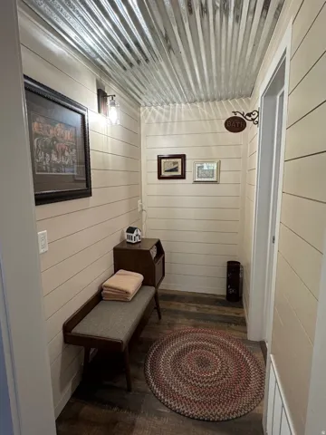 Corridor with wooden walls and dark wood finished floors