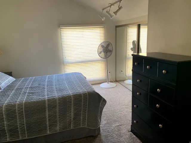 Bedroom featuring light carpet and vaulted ceiling
