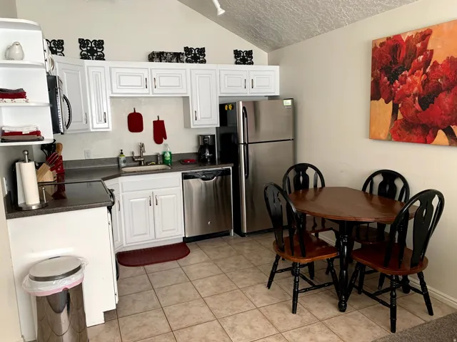 Kitchen featuring dark countertops, white cabinetry, and stainless steel appliances