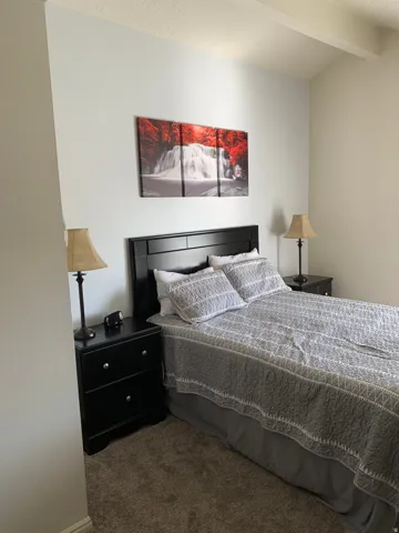 Bedroom featuring carpet and vaulted ceiling