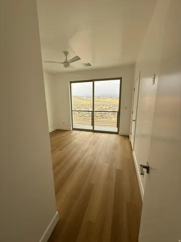 Empty room with wood finished floors and ceiling fan