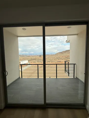 Doorway with a mountain view, wood finished floors, and plenty of natural light